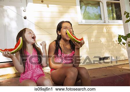 Two laughing girls sitting on house porch with slices of watermelon View Large Photo Image Stock Image - Two laughing girls sitting on house porch with slices of watermelon. Fotosearch