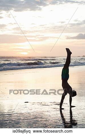 Young man doing handstand on beach at sunset, Nosara, Guanacaste, Costa Rica View Large Photo Image Stock Photography - Young man doing handstand on beach at sunset, Nosara, Guanacaste, Costa Rica. Fotosearch