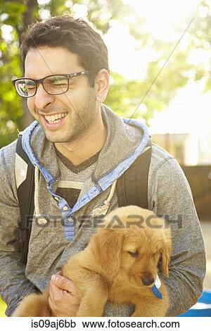 Young man holding labrador puppy View Large Photo Image Stock Image - Young man holding labrador puppy. Fotosearch