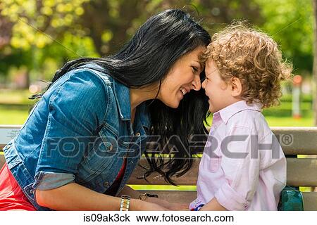Young mother and son face to face on park bench View Large Photo Image Stock Image - Young mother and son face to face on park bench. Fotosearch