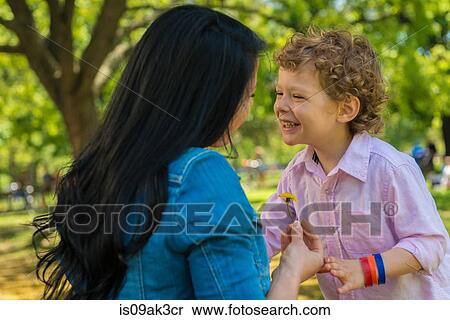 Young mother and son laughing together in park View Large Photo Image Stock Photography - Young mother and son laughing together in park. Fotosearch