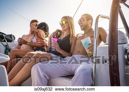Young people on yacht with drinks, laughing View Large Photo Image Stock Image - Young people on yacht with drinks, laughing. Fotosearch