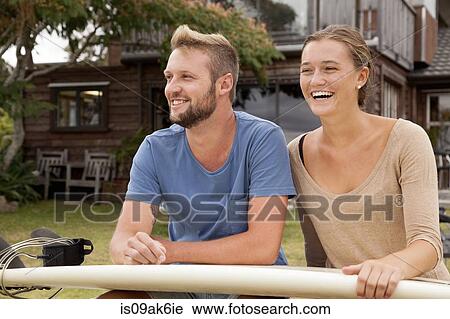 Young surfer couple with surfboard on lap View Large Photo Image Stock Image - Young surfer couple with surfboard on lap. Fotosearch