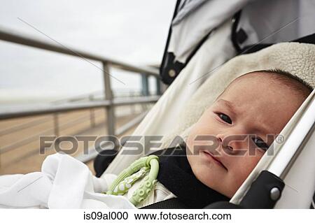 Stock Image - Baby boy in pushchair. Fotosearch