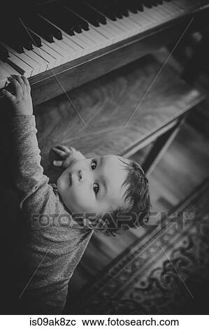 Black and white candid portrait of a baby girl playing piano View Large Photo Image Stock Image - Black and white candid portrait of a baby girl playing piano. Fotosearch