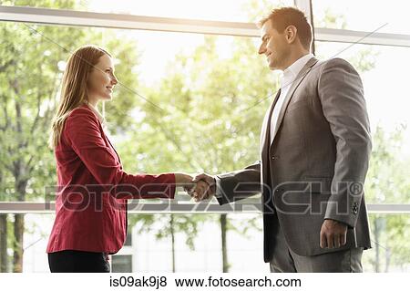 Stock Photo - Businesswoman and businessman shaking hands. Fotosearch