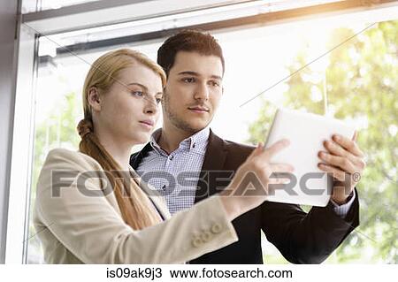 Businesswoman and businessman using digital tablet for discussion View Large Photo Image Stock Image - Businesswoman and businessman using digital tablet for discussion. Fotosearch