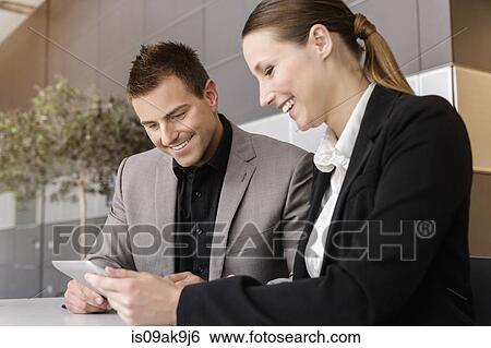 Businesswoman and businessman using digital tablet for discussion View Large Photo Image Stock Photograph - Businesswoman and businessman using digital tablet for discussion. Fotosearch