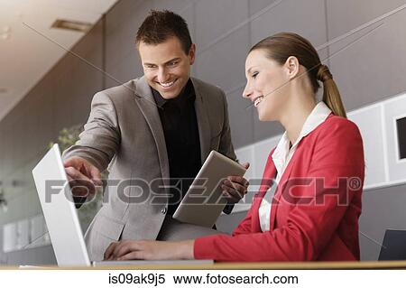 Stock Photography - Businesswoman and businessman using digital tablet for discussion. Fotosearch