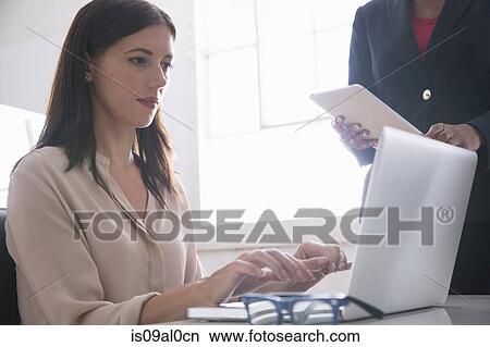 Picture - Businesswoman using laptop. Fotosearch
