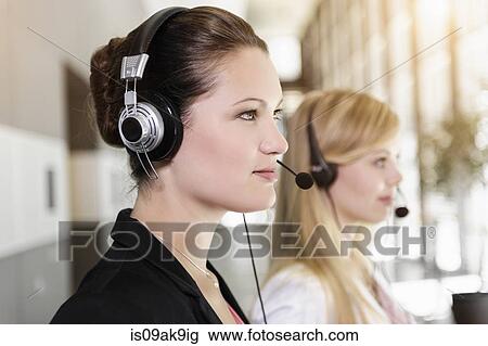 Stock Image - Call centre team wearing headsets. Fotosearch