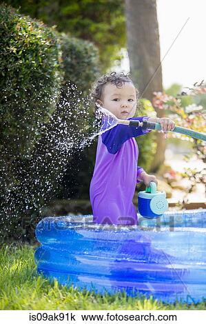 Candid portrait of a baby girl with hosepipe in paddling pool View Large Photo Image Stock Image - Candid portrait of a baby girl with hosepipe in paddling pool. Fotosearch