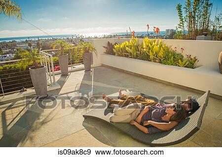 Couple lying on sun lounger in penthouse rooftop garden, La Jolla, California, USA View Large Photo Image Stock Photo - Couple lying on sun lounger in penthouse rooftop garden, La Jolla, California, USA. Fotosearch