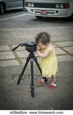 Cute baby girl playing with a tripod View Large Photo Image Picture - Cute baby girl playing with a tripod. Fotosearch