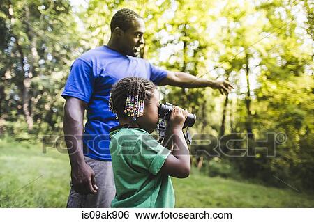 Father and daughter watching with binoculars in forest eco camp View Large Photo Image Stock Photograph - Father and daughter watching with binoculars in forest eco camp. Fotosearch