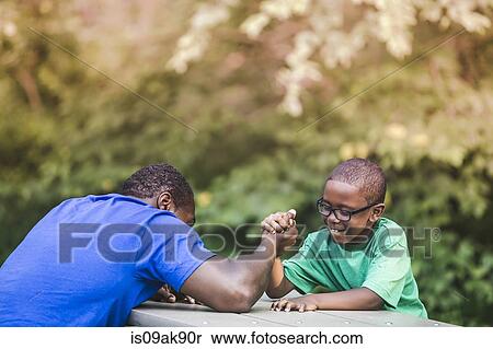 Father arm wrestling with son at parkland eco camp View Large Photo Image Stock Photography - Father arm wrestling with son at parkland eco camp. Fotosearch