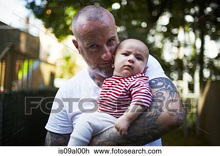Stock Image - Father holding baby son. Fotosearch