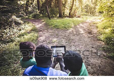 Father with daughter and son navigating with digital tablet in forest eco camp View Large Photo Image Stock Photo - Father with daughter and son navigating with digital tablet in forest eco camp. Fotosearch