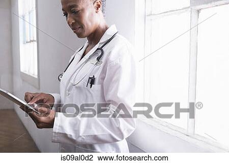 Female doctor using digital tablet View Large Photo Image Stock Image - Female doctor using digital tablet. Fotosearch