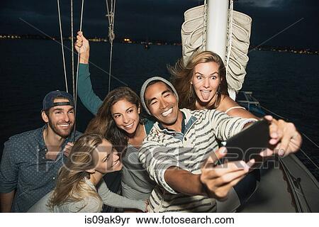 Friends on sailing boat photographing themselves View Large Photo Image Stock Photography - Friends on sailing boat photographing themselves. Fotosearch
