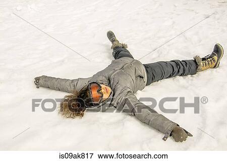 Stock Photo - Girl lying on her back in snow. Fotosearch