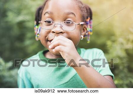 Stock Image - Girl smelling plant in parkland eco camp. Fotosearch