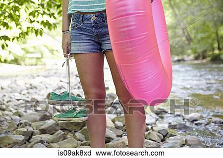 Stock Image - Hiker in forest with inflatable ring. Fotosearch