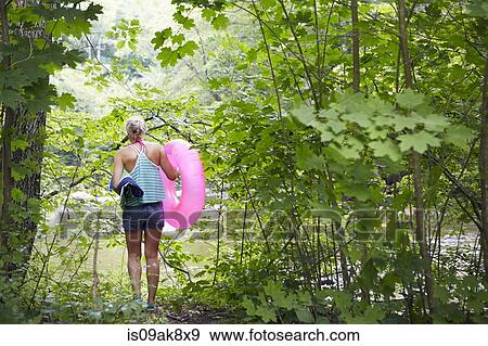 Hiker in forest with inflatable ring View Large Photo Image Stock Photo - Hiker in forest with inflatable ring. Fotosearch