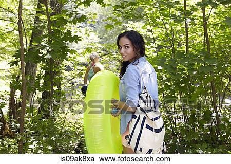 Stock Image - Hikers in forest with inflatable ring. Fotosearch