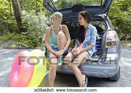 Hikers sitting at rear of car with inflatable rings View Large Photo Image Stock Photography - Hikers sitting at rear of car with inflatable rings. Fotosearch