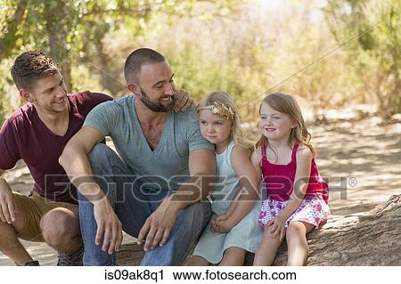 Male couple sitting on riverbank with two daughters View Large Photo Image Stock Image - Male couple sitting on riverbank with two daughters. Fotosearch