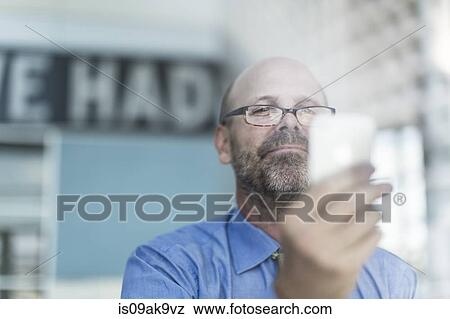 Mature businessman wearing glasses using cell phone View Large Photo Image Stock Photo - Mature businessman wearing glasses using cell phone. Fotosearch