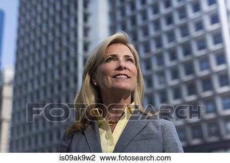 Mature businesswoman in front of building, looking away View Large Photo Image Stock Image - Mature businesswoman in front of building, looking away. Fotosearch