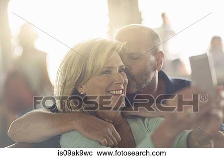 Stock Image - Mature couple photographing themselves. Fotosearch