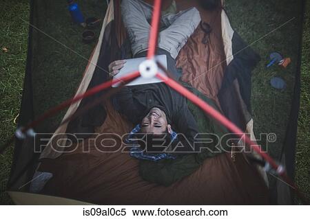 Mature man lying in tent using digital tablet, high angle View Large Photo Image Stock Photography - Mature man lying in tent using digital tablet, high angle. Fotosearch