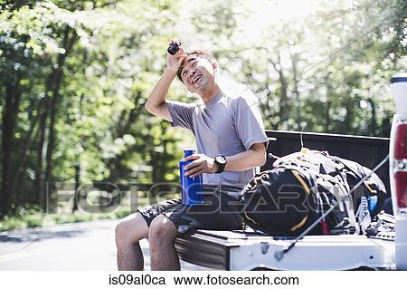 Mature man sitting on pick up truck, wiping brow View Large Photo Image Stock Image - Mature man sitting on pick up truck, wiping brow. Fotosearch