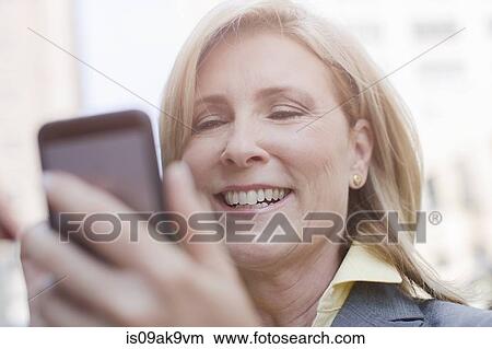 Mature woman using smartphone, close up View Large Photo Image Picture - Mature woman using smartphone, close up. Fotosearch