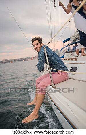 Mid adult man sitting on boat deck View Large Photo Image Stock Photo - Mid adult man sitting on boat deck. Fotosearch
