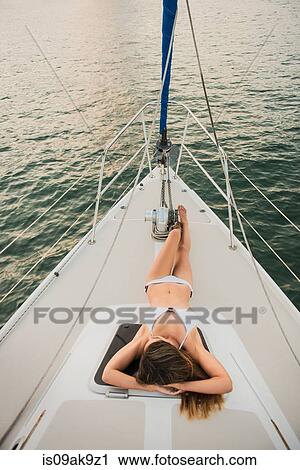 Mid adult woman lying on boat deck wearing bikini View Large Photo Image Stock Image - Mid adult woman lying on boat deck wearing bikini. Fotosearch