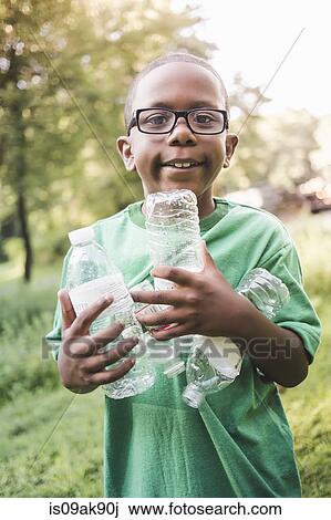 Portrait of boy holding with plastic bottles in parkland eco camp View Large Photo Image Stock Image - Portrait of boy holding with plastic bottles in parkland eco camp. Fotosearch