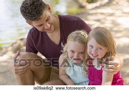 Portrait of father and two daughters on riverbank View Large Photo Image Stock Image - Portrait of father and two daughters on riverbank. Fotosearch