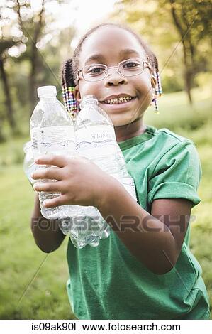 Portrait of girl holding with plastic bottles in parkland eco camp View Large Photo Image Stock Image - Portrait of girl holding with plastic bottles in parkland eco camp. Fotosearch
