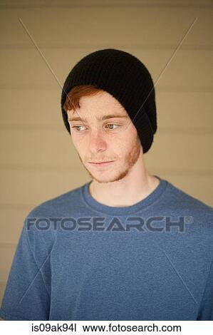 Stock Image - Portrait of teenage boy in beanie hat looking sideways. Fotosearch