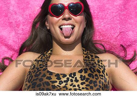 Portrait of young woman sunbathing pulling a face View Large Photo Image Stock Photograph - Portrait of young woman sunbathing pulling a face. Fotosearch
