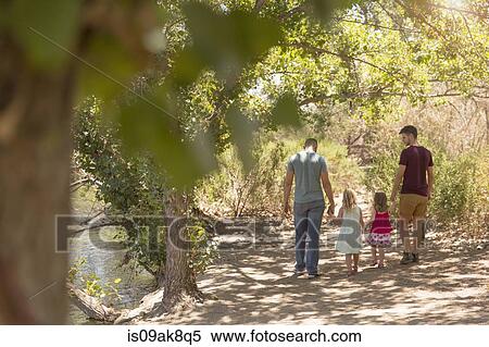 Rear view of male couple strolling with two daughters in park View Large Photo Image Stock Photography - Rear view of male couple strolling with two daughters in park. Fotosearch
