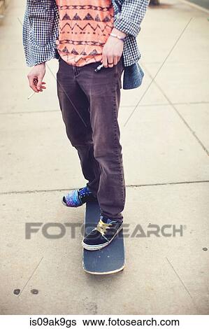 Skateboarder's legs on concrete pavement View Large Photo Image Stock Photograph - Skateboarder's legs on concrete pavement. Fotosearch