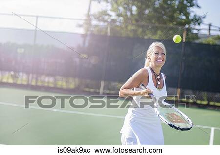 Smiling mature woman playing tennis View Large Photo Image Stock Image - Smiling mature woman playing tennis. Fotosearch