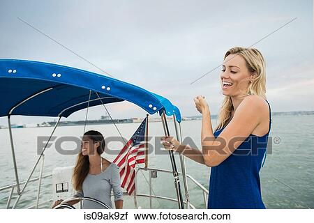 Two women on sailing boat laughing View Large Photo Image Stock Image - Two women on sailing boat laughing. Fotosearch