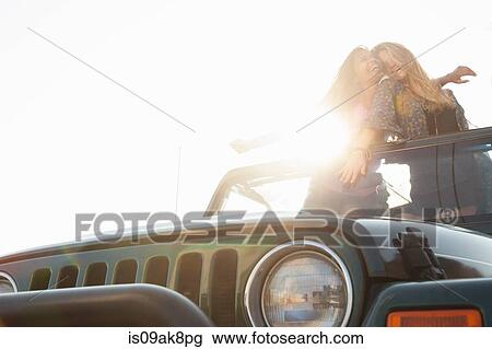 Two young women standing up in back of jeep View Large Photo Image Stock Image - Two young women standing up in back of jeep. Fotosearch