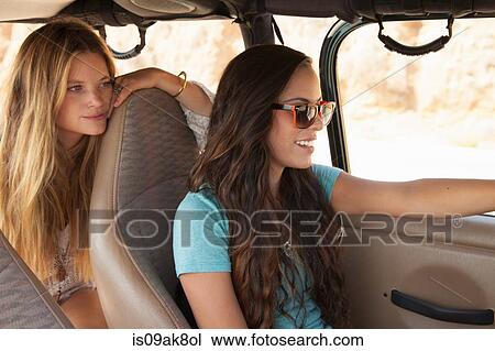 Two young women traveling in car View Large Photo Image Stock Image - Two young women traveling in car. Fotosearch
